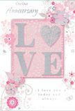 This anniversary card design captures the feeling of a cherished love story, wrapped in a palette of soft pastel pinks, ivory whites, and understated silvers that call to mind spring blossoms opening along the paths near Russia Dock Woodland. In the centre, the word "LOVE" is the clear focal point, crafted from raised, softly sparkling glitter so that each letter appears both substantial and delicate. The "O" is subtly suggested as a heart-shaped curve within the lettering, its shimmer a fraction brighter, like the highlight on a polished silver charm. Around this central word, a halo of delicate blooms and winding vines spreads outward. The flowers are illustrated with fine, flowing lines, their petals washed in translucent blush and pale mauve, giving them a watercolor lightness. Small details-tiny petals, curled tendrils, and a few discreet butterflies-add a sense of movement, as if a gentle breeze is drifting over a carefully arranged anniversary bouquet on a windowsill overlooking the Thames. The background is a soft, powdery pink, gently shaded so it feels almost velvety to the eye. Scripted phrases, including sentiments akin to "On Our Anniversary" and "I love you today and always," are written in an elegant yet modest cursive, placed so they cradle the floral design without overwhelming it. The overall composition conveys intimacy and quiet joy, much like a private toast shared at home after flowers have been delivered from a local Rotherhithe florist. Every element-the shimmer, the florals, the flowing words-works together to celebrate a love that is tender, enduring, and deeply personal.